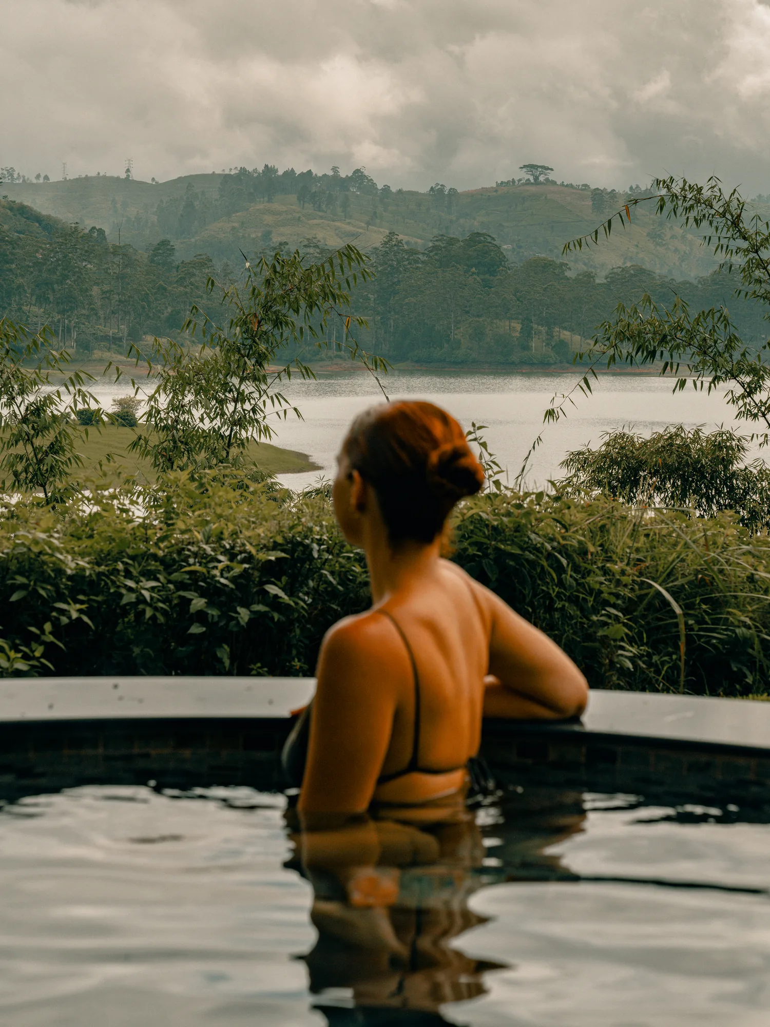 Guest relaxing beside the pool overlooking the highlands at Ceylon Tea Trails